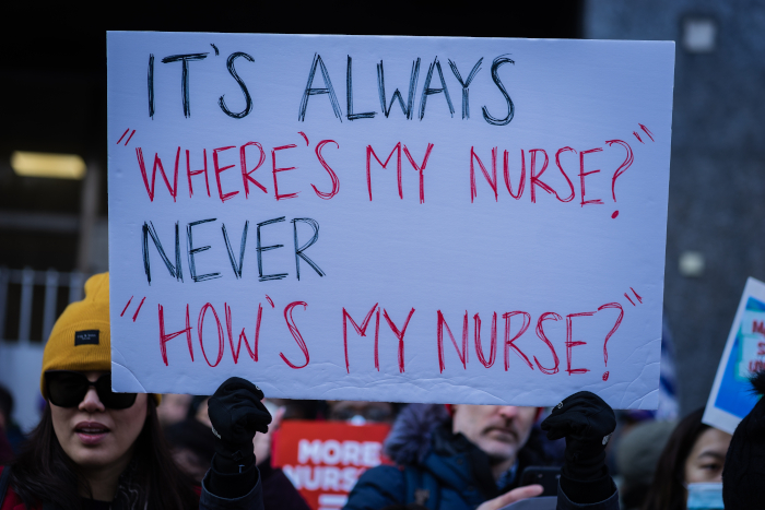 Protest sign: "It's always 'where's my nurse,' never..."